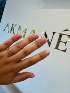 Ranka su rožiniu manikiūru ir žiedu